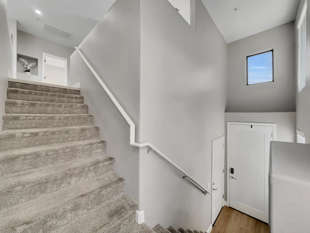 A bright and spacious entryway featuring a staircase leading up from the front door, accompanied by a window that lets in natural light. The foyer offers a sense of arrival and a welcoming transition from the ground level.
