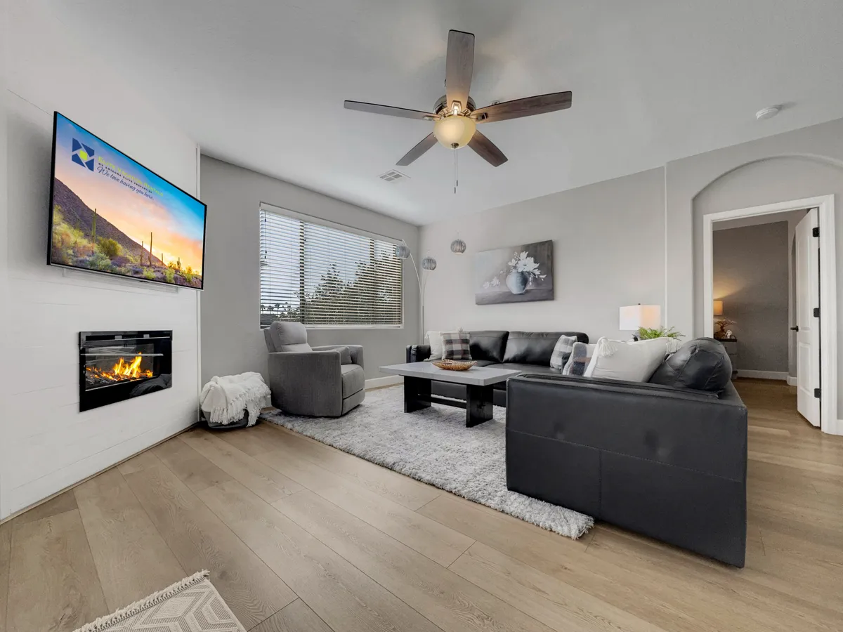 A cozy living space featuring a fireplace, TV, sofa, and coffee table, arranged for relaxation and socialization. The inviting atmosphere suggests evenings spent watching movies or playing games with loved ones.